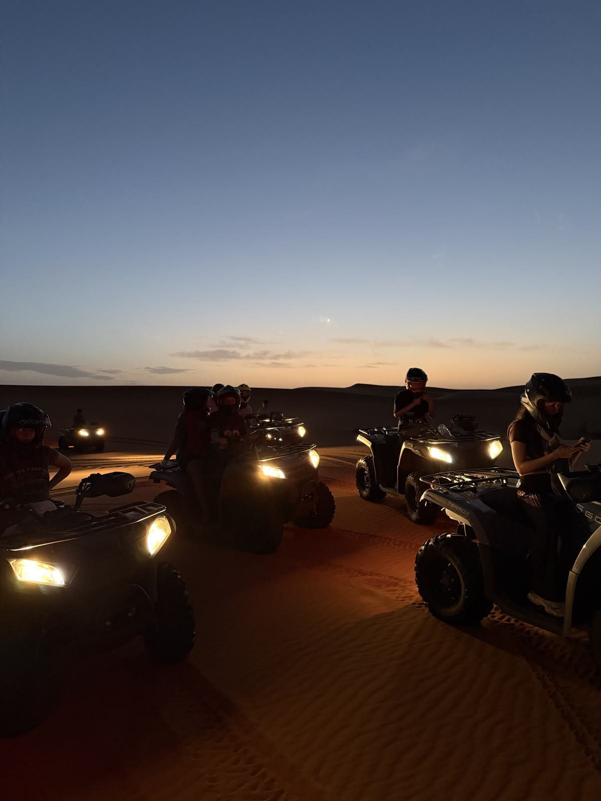 RAW CIRCLE members on quad bikes in the desert at dusk